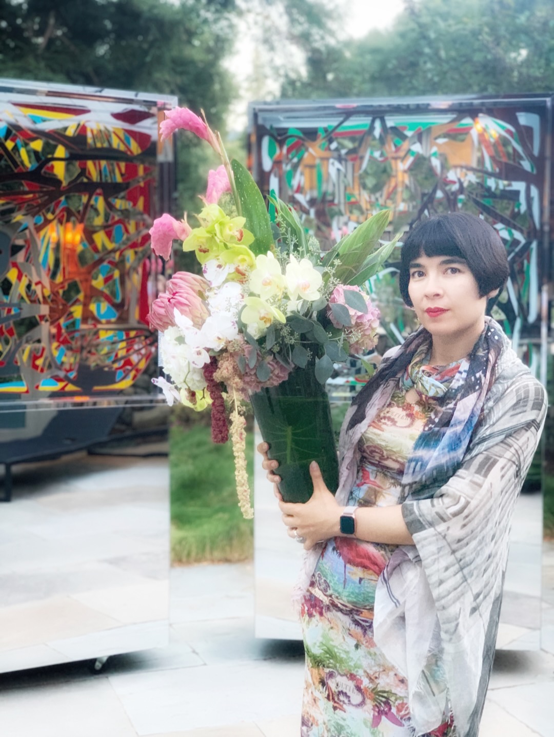 Drue Kataoka holding a bouquet of orchids between two Ambrosias at dusk