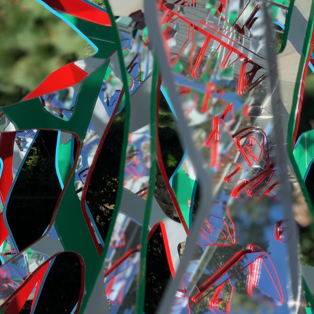 Detail of green, red and silver Ambrosia panels with red line work tracing across the mirrored surfaces