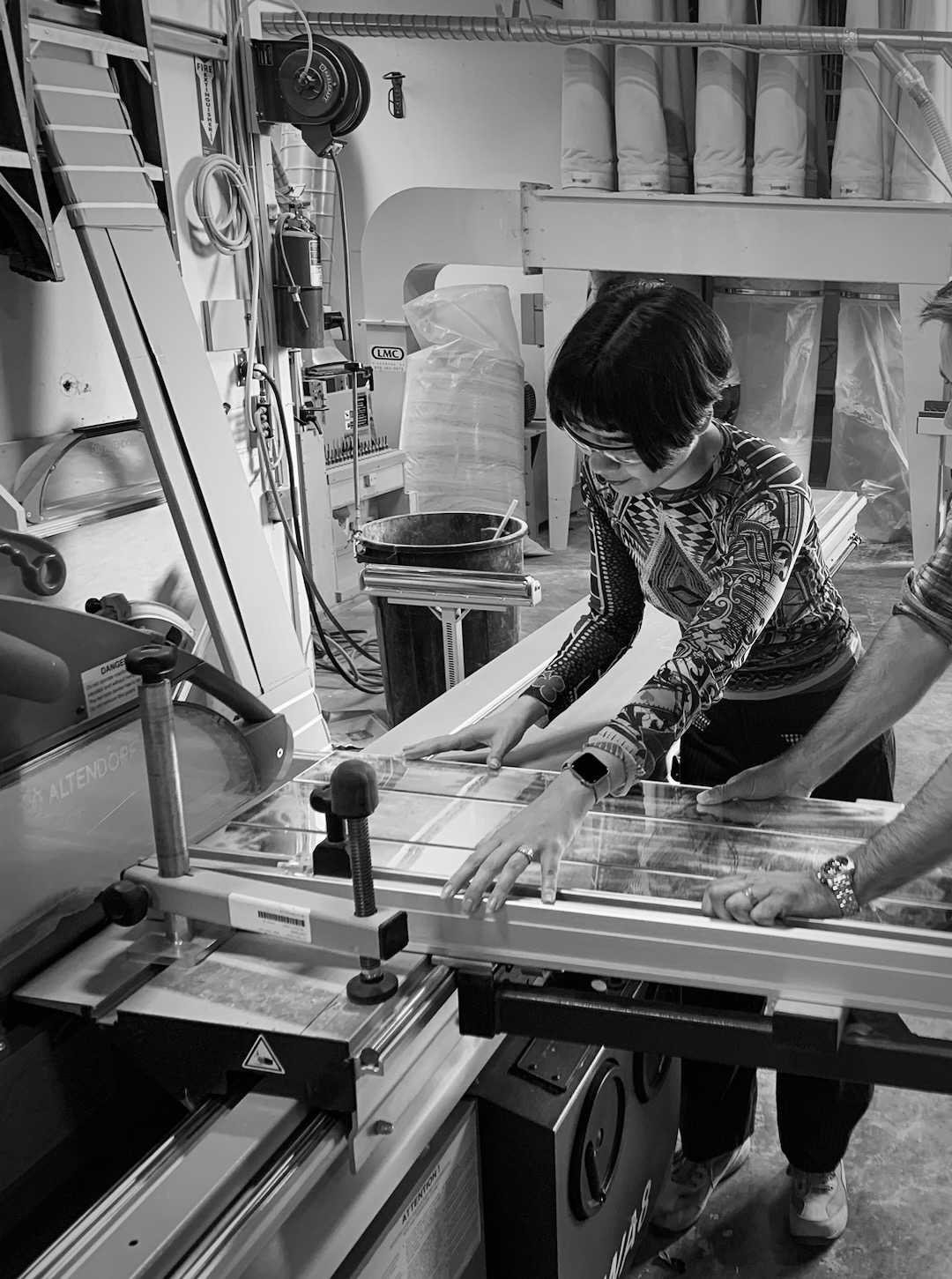 Drue Kataoka cutting a mirror panel to precise tolerances on the studio's panel saw