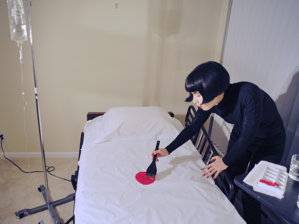 Drue placing the painted red spot on the hospital bed